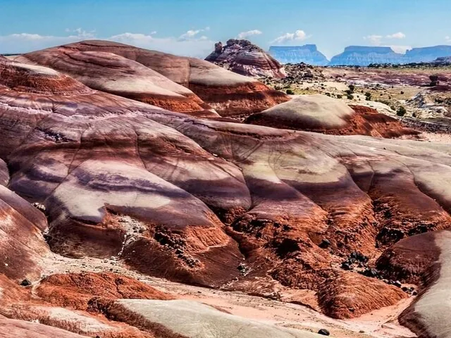 Scenic view of Bentonite Hills with rolling colorful mounds under a blue sky