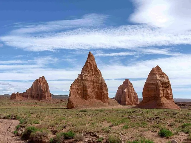 Tall sandstone monoliths rising from a desert plain in Cathedral Valley.