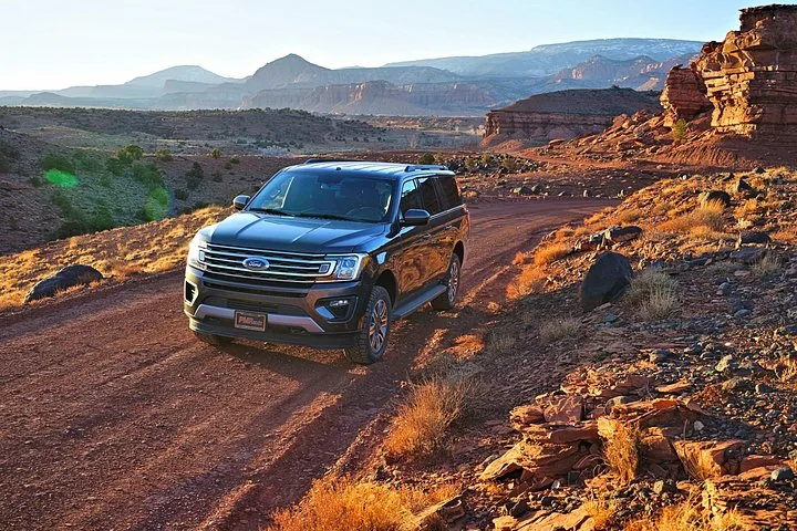 Ein dunkler Ford Expedition auf einer malerischen Schotterstraße.