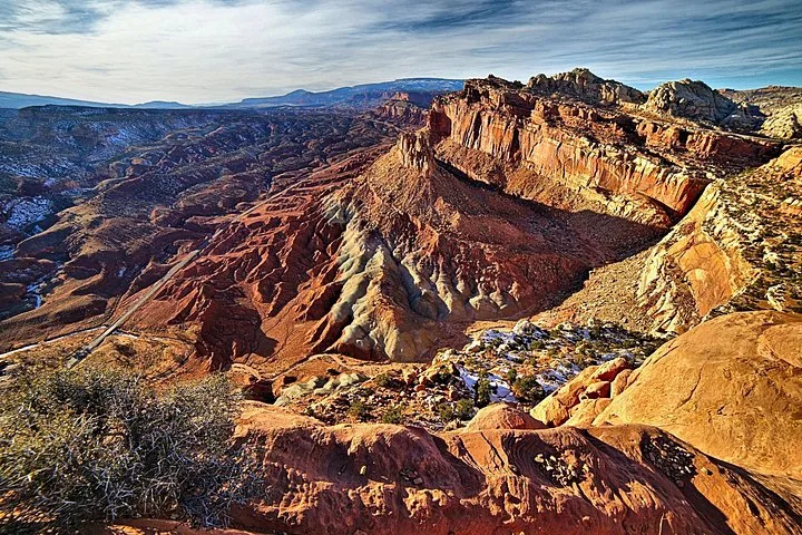 Une vue étendue sur des canyons accidentés et colorés et des formations rocheuses.