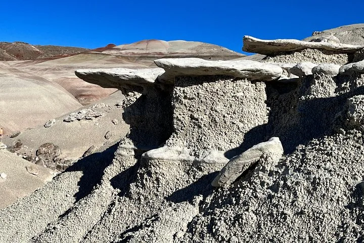 Close-up van getextureerde, lichtgekleurde hoodoo-rotsformaties in een woestijnlandschap.