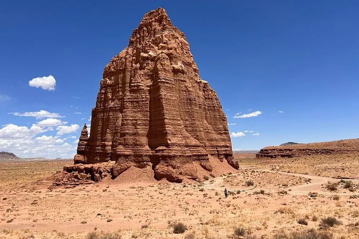 A massive, striking sandstone monolith standing in the desert at Cathedral Valley.