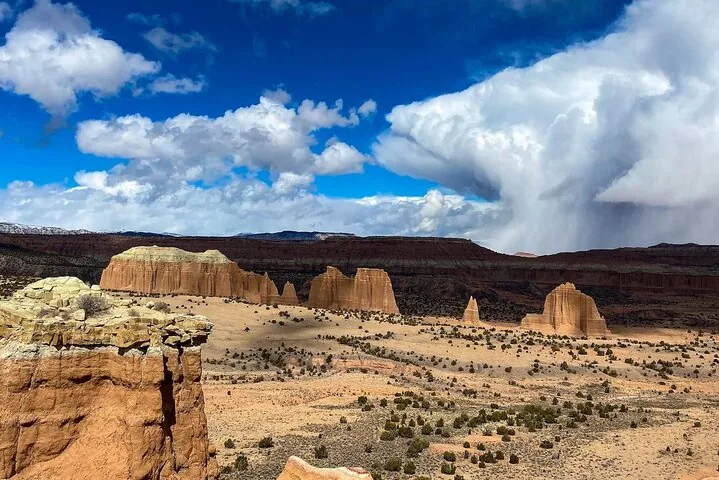 Weiter Blick über das Cathedral Valley mit Sandsteinmonolithen und Gewitterwolken.