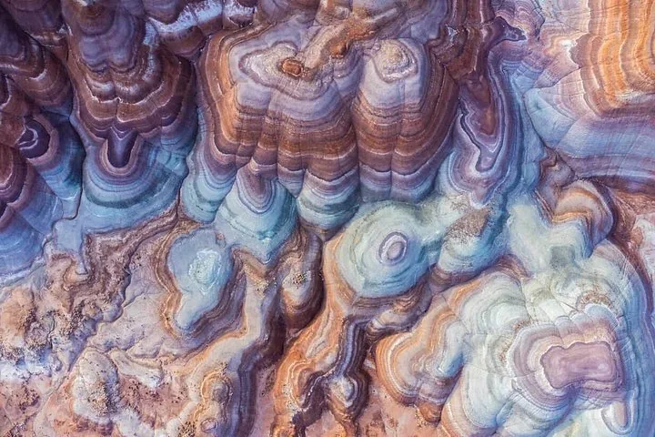 Vista aérea de formaciones geológicas que muestran vibrantes franjas de roca de colores